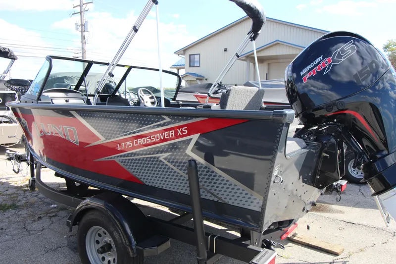 Slide: The Image of 2024 Lund 1775 Crossover XS boat with Mercury engine, parked outdoors. - 3