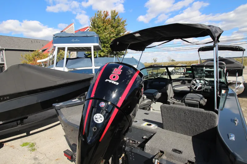 Slide: The Image of 2024 Lund 1775 Crossover XS boat with powerful 150 HP engine, parked outdoors. - 4