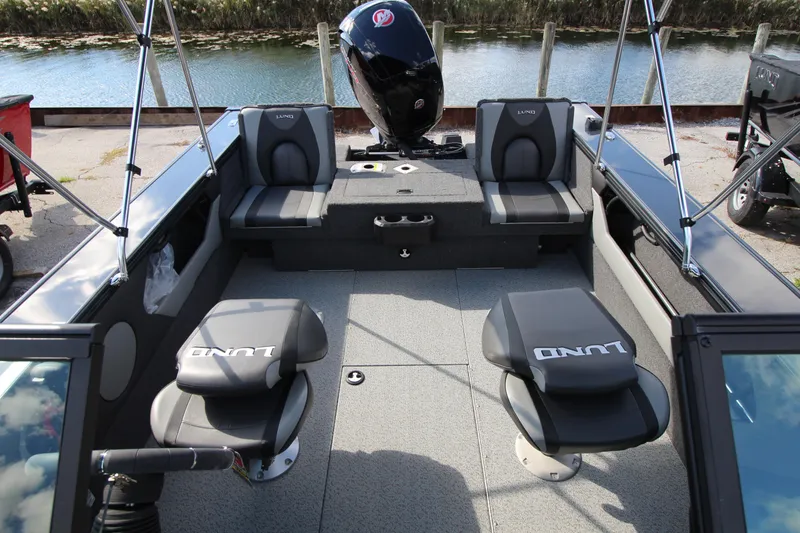 Slide: The Image of 2024 Lund 1775 Crossover XS boat interior with seating and motor. - 7