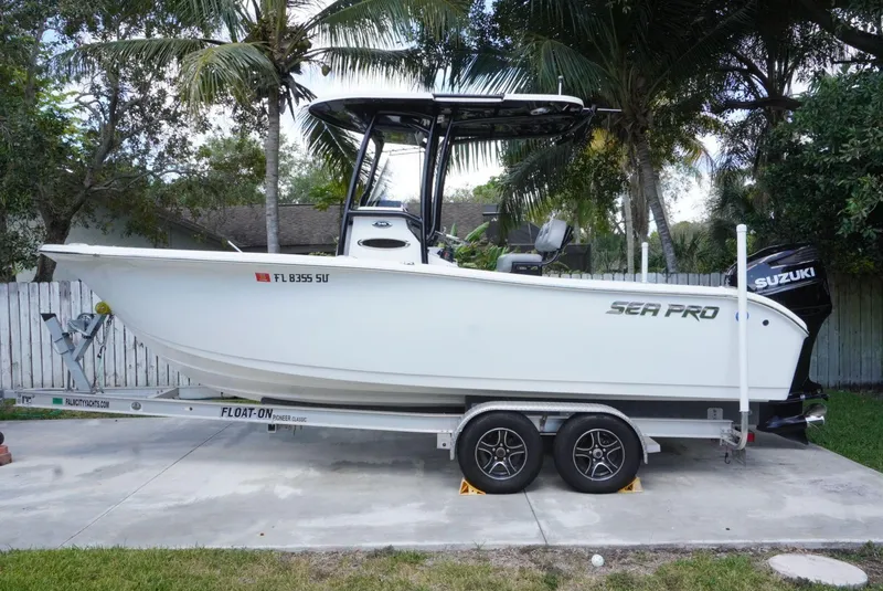 The Image of 2021 Sea Pro 219 boat on trailer with Suzuki engine, parked outdoors. - 0