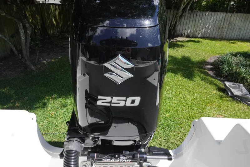 Slide: The Image of Suzuki 250 outboard motor on 2021 Sea Pro 219 boat, parked on grass. - 12