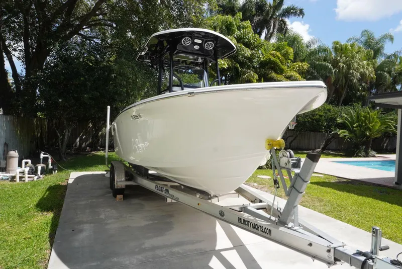 Slide: The Image of 2021 Sea Pro 219 boat on trailer, parked in a driveway with lush greenery. - 3