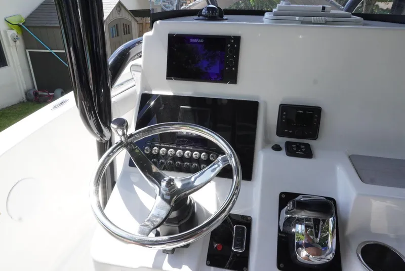 Slide: The Image of 2021 Sea Pro 219 boat dashboard with steering wheel and navigation controls. - 8