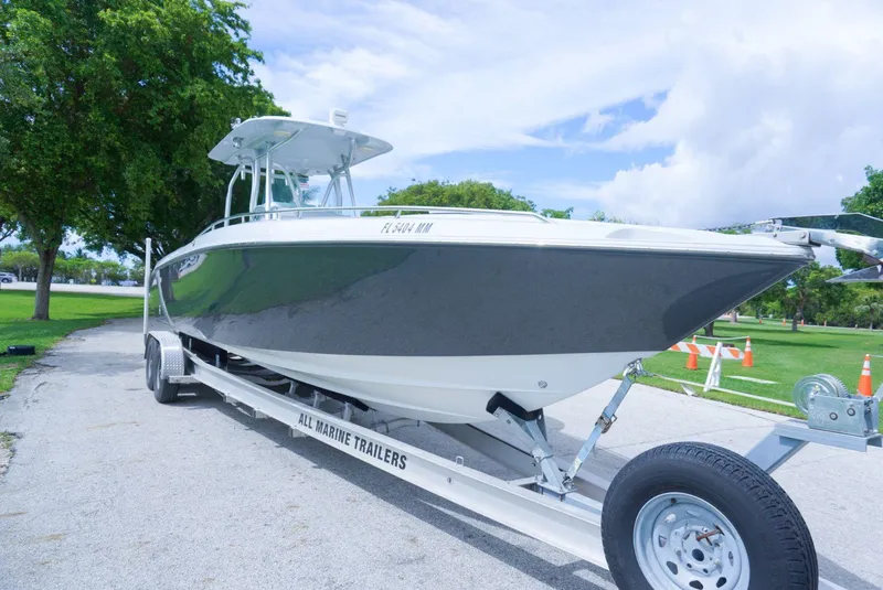 Slide: The Image of 2004 Baja 340 Sportfish boat on trailer, parked outdoors with trees and sky in background. - 14