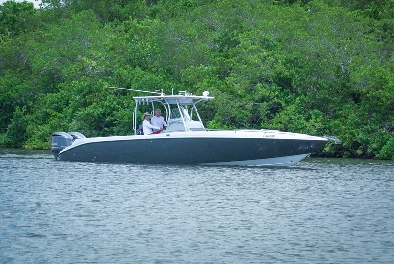 Slide: The Image of 2004 Baja 340 Sportfish boat on calm water near lush greenery. - 2