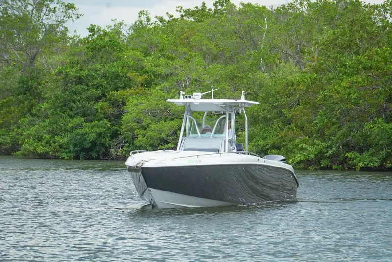 Slide: The Image of 2004 Baja 340 Sportfish boat on calm water, surrounded by lush greenery. - 3