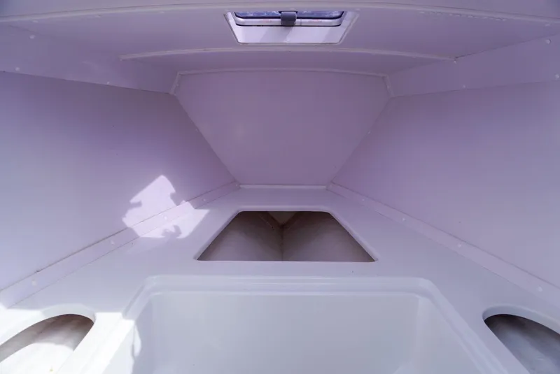 Slide: The Image of 2004 Baja 340 Sportfish cabin interior, featuring a clean, white design with storage compartments. - 32