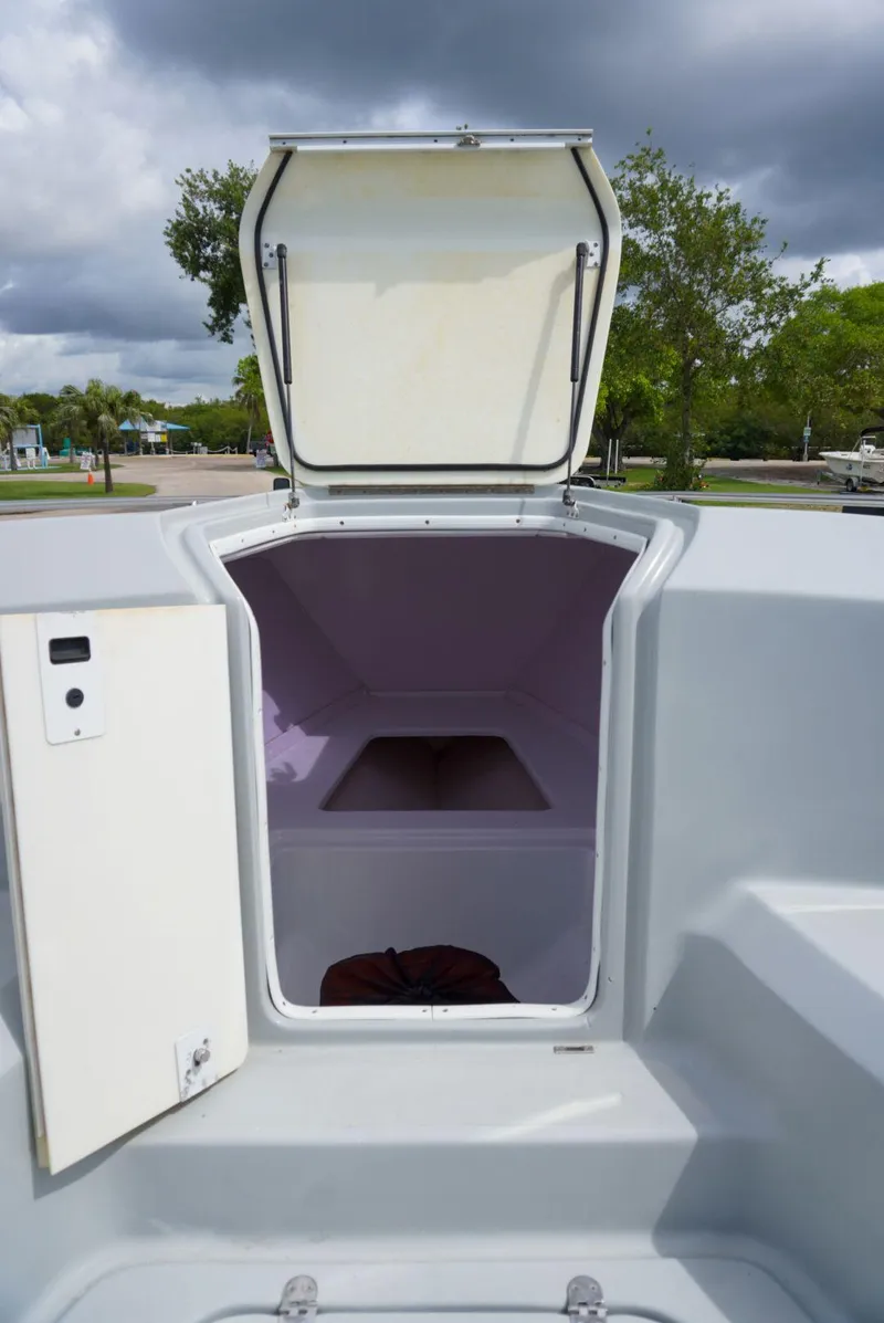 Slide: The Image of 2004 Baja 340 Sportfish boat storage compartment with open hatch, under cloudy sky. - 33