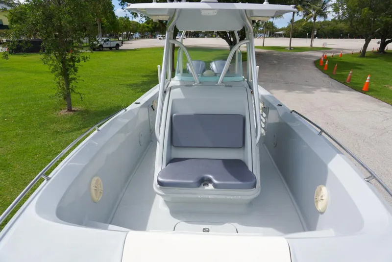 Slide: The Image of 2004 Baja 340 Sportfish boat with seating, parked on a sunny day near a grassy area. - 34