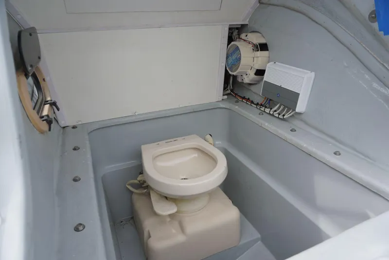 Slide: The Image of 2004 Baja 340 Sportfish boat interior with compact marine toilet setup. - 37