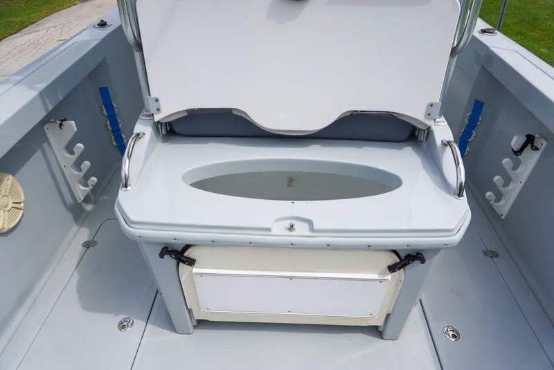 Slide: The Image of 2004 Baja 340 Sportfish boat interior with open storage compartment and rod holders. - 38