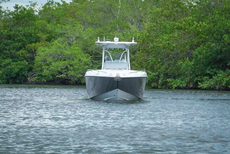 Slide: The Image of 2004 Baja 340 Sportfish boat on calm water, surrounded by lush greenery. - 4