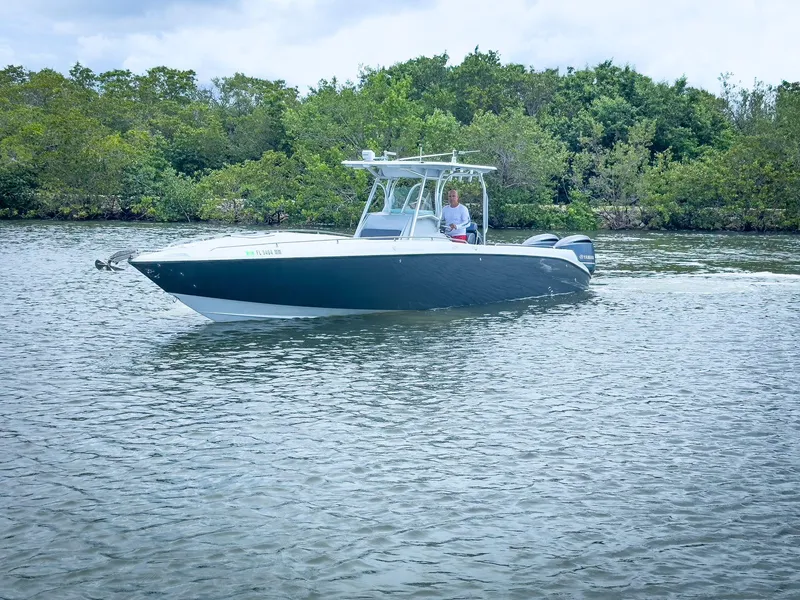 Slide: The Image of 2004 Baja 340 Sportfish boat cruising on a calm river with lush greenery. - 40