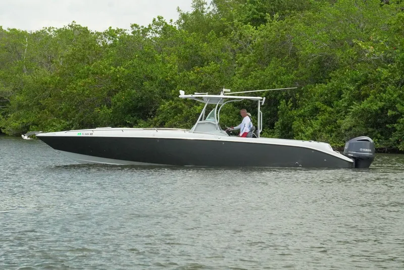 Slide: The Image of 2004 Baja 340 Sportfish boat on calm water near lush greenery. - 5