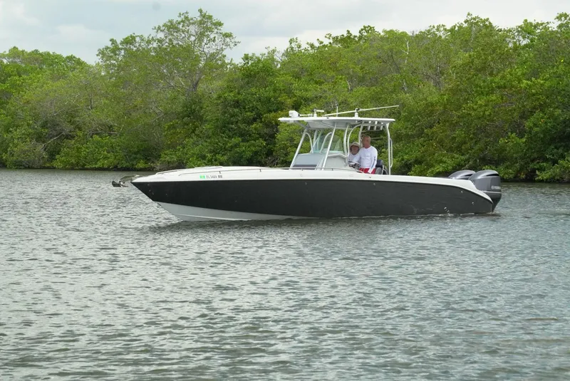 Slide: The Image of 2004 Baja 340 Sportfish boat cruising on a calm river with lush greenery. - 6