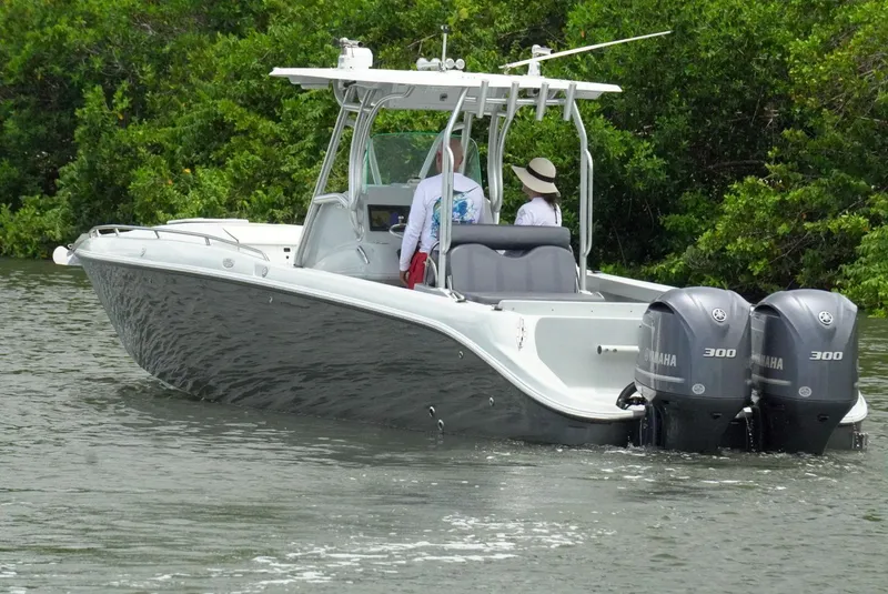 Slide: The Image of 2004 Baja 340 Sportfish boat with dual Yamaha 300 engines on a calm waterway. - 7