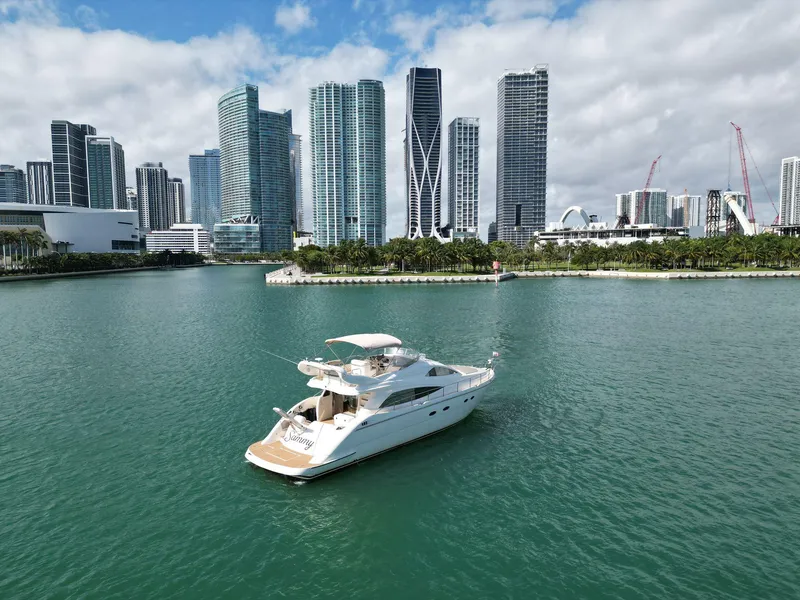 Slide: The Image of Aicon 56 yacht from 2003 cruising near a city skyline with tall buildings. - 14