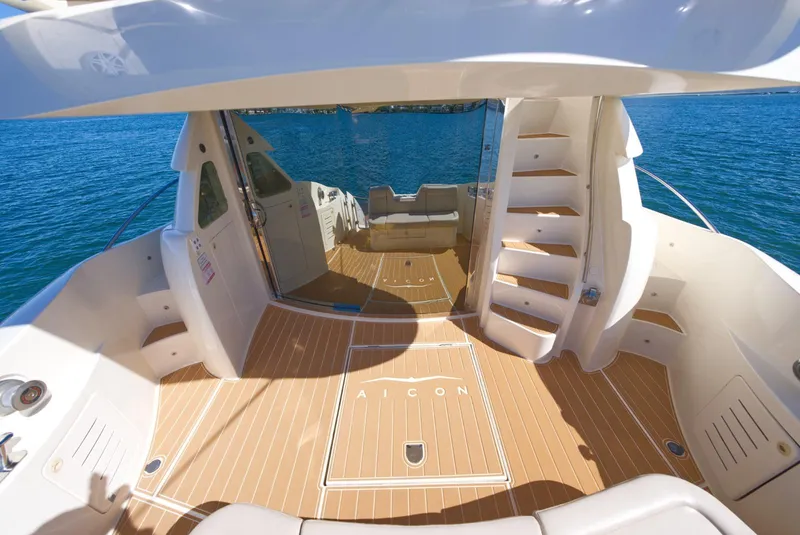 Slide: The Image of Luxurious 2003 Aicon 56 yacht interior with wooden deck and staircase, overlooking blue water. - 38