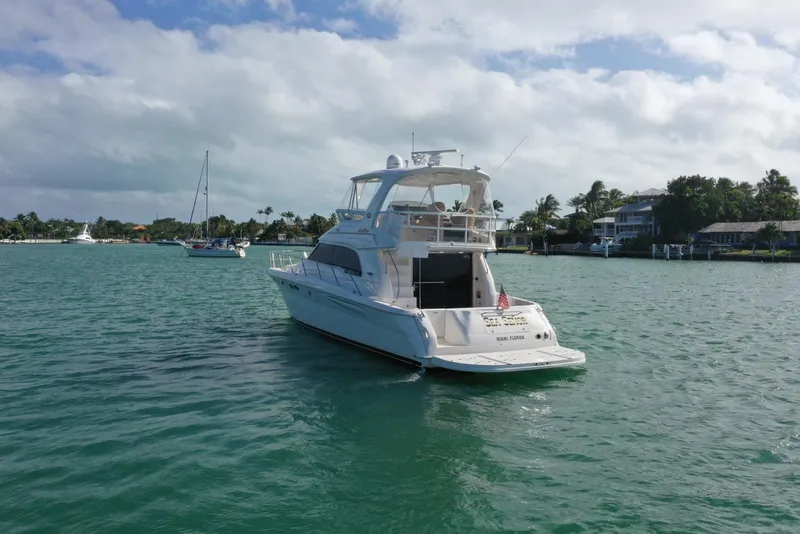 Slide: The Image of 2001 Sea Ray 480 Sedan Bridge yacht on calm waters, scenic background. - 17