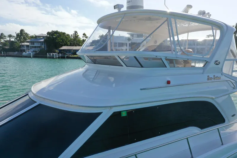 Slide: The Image of 2001 Sea Ray 480 Sedan Bridge yacht on calm waters near waterfront homes. - 26