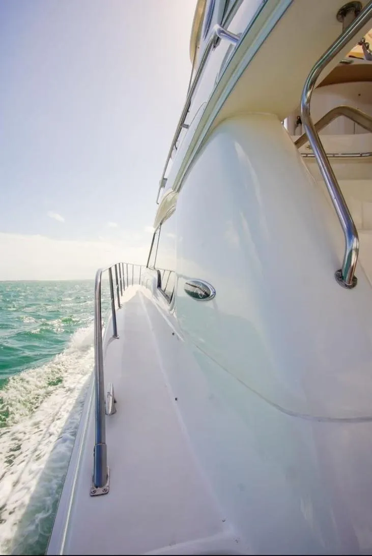 Slide: The Image of Side view of 2001 Sea Ray 480 Sedan Bridge yacht cruising on open water. - 33