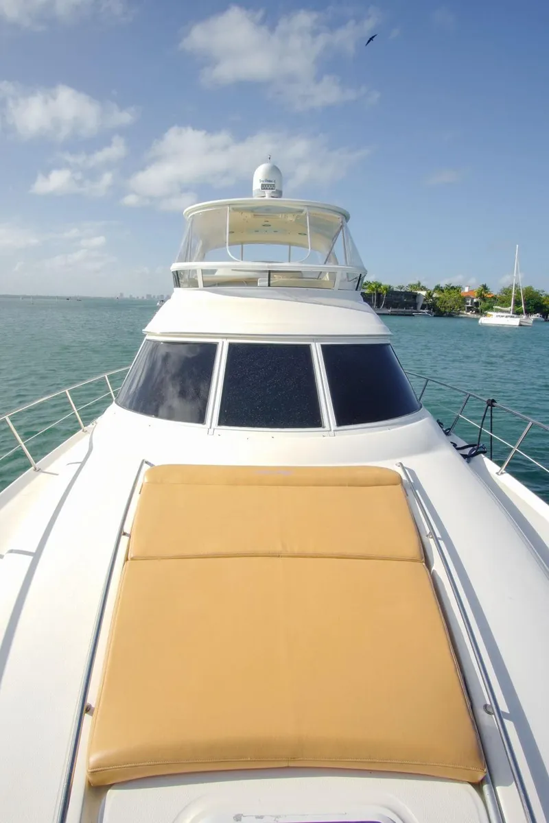 Slide: The Image of 2001 Sea Ray 480 Sedan Bridge yacht on calm waters under a clear sky. - 34