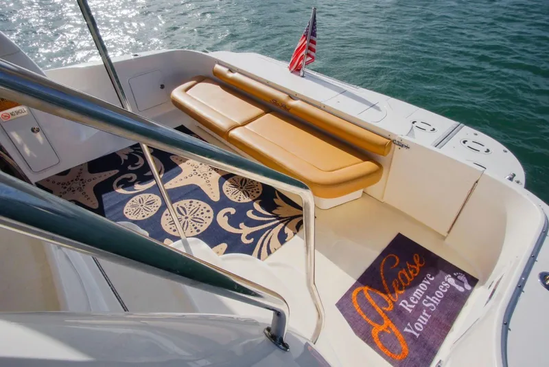 Slide: The Image of 2001 Sea Ray 480 Sedan Bridge deck with seating, rug, and "Please Remove Your Shoes" mat. - 35