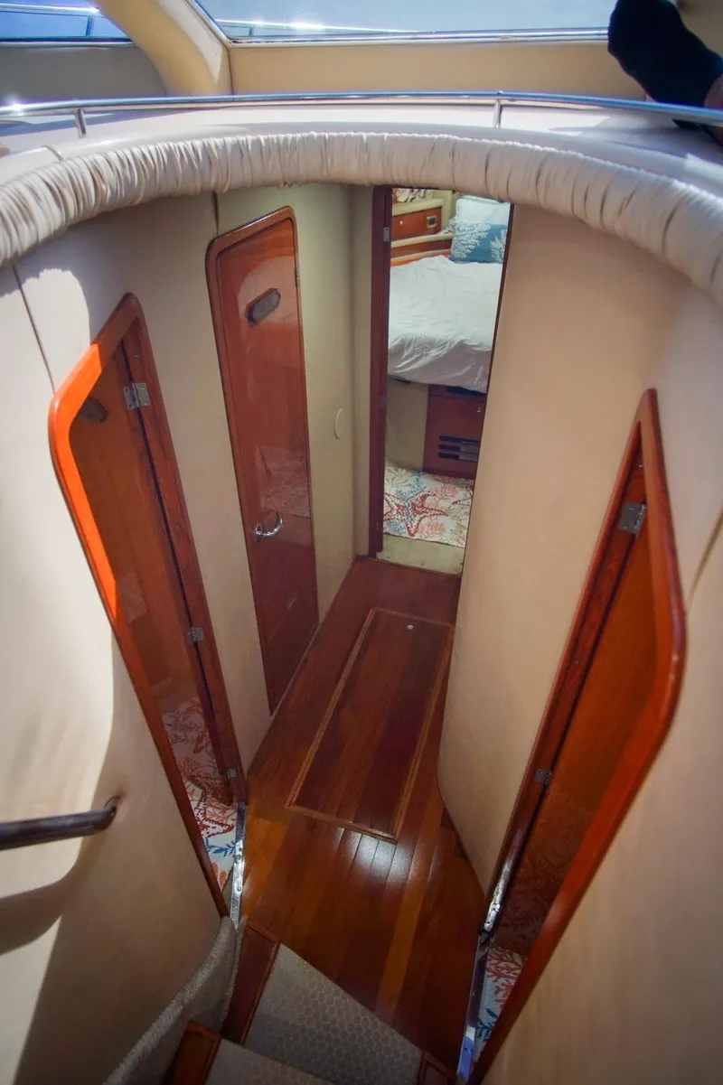 Slide: The Image of Interior hallway of 2001 Sea Ray 480 Sedan Bridge yacht with wooden doors and flooring. - 42