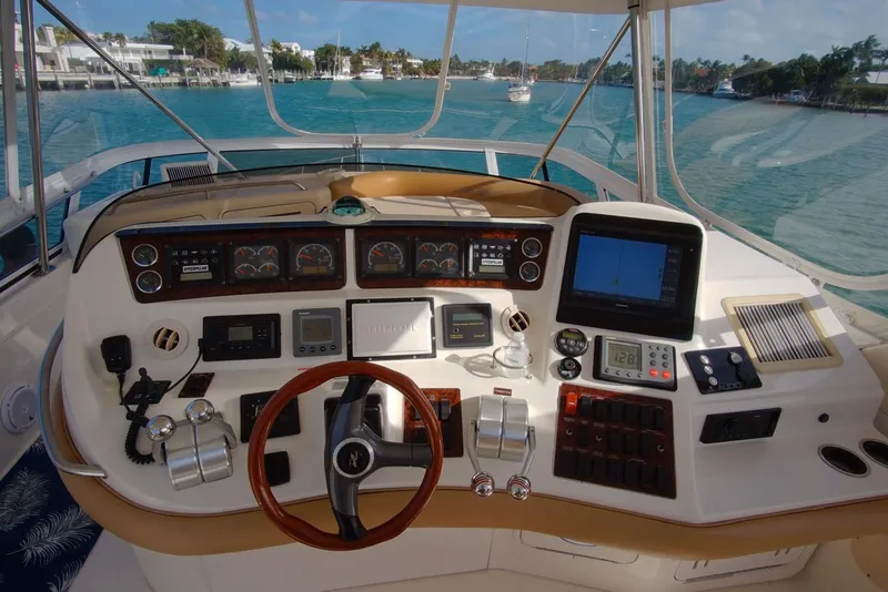 Slide: The Image of 2001 Sea Ray 480 Sedan Bridge helm with navigation instruments and scenic water view. - 44