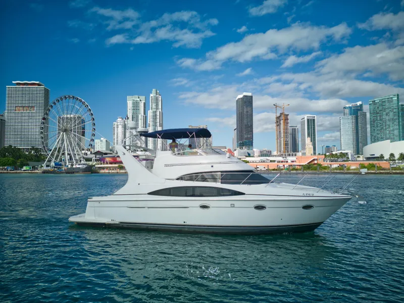 The Image of 2002 Carver 410 Sport Sedan yacht cruising near city skyline and Ferris wheel. - 0