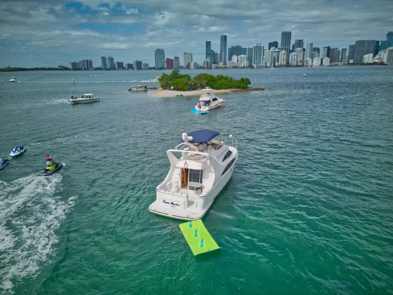 Slide: The Image of 2002 Carver 410 Sport Sedan yacht on water near city skyline and small island. - 18