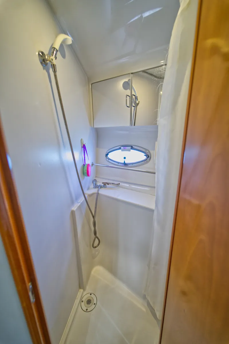Slide: The Image of Shower area in 2002 Carver 410 Sport Sedan yacht, featuring compact design and porthole window. - 15