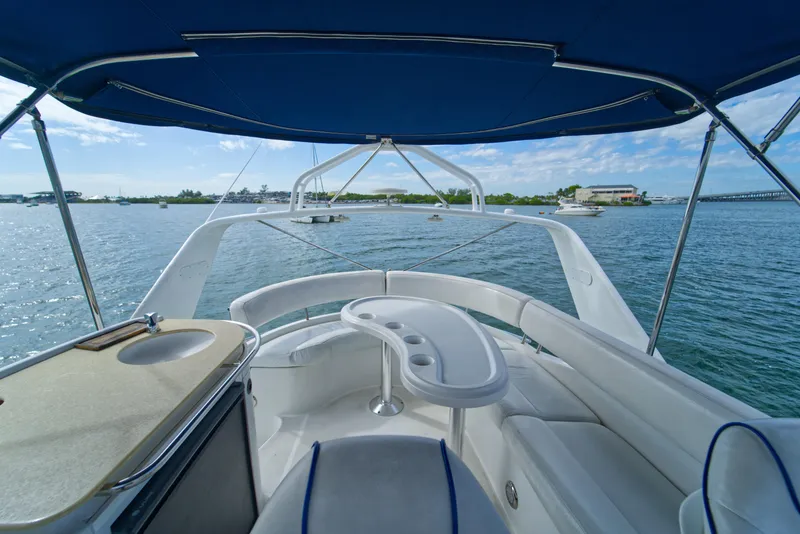 Slide: The Image of 2002 Carver 410 Sport Sedan yacht interior with blue canopy, overlooking serene waters. - 5
