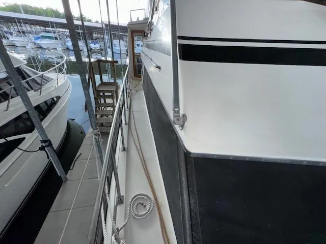 Slide: The Image of 1987 Seamaster 48 Motor Yacht docked, showcasing side deck and railing. - 11