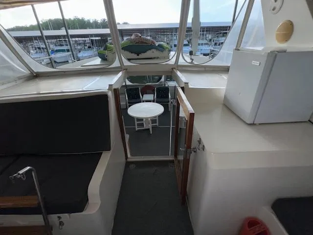 Slide: The Image of 1987 Seamaster 48 Motor Yacht interior with seating, table, and marina view. - 17