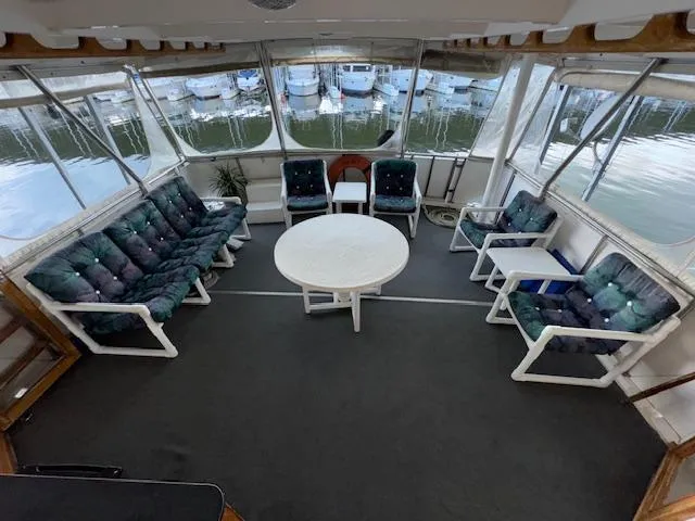 Slide: The Image of 1987 Seamaster 48 Motor Yacht interior with cushioned seating and round table, docked at marina. - 18