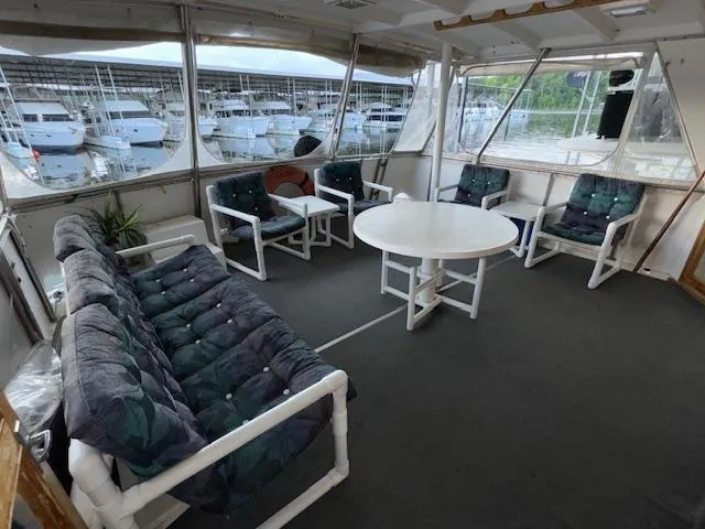 Slide: The Image of 1987 Seamaster 48 Motor Yacht interior with cushioned seating and round table, docked at marina. - 19