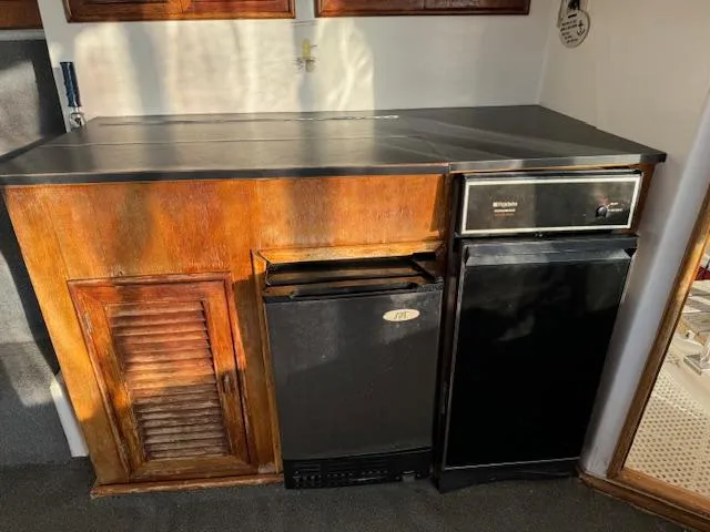 Slide: The Image of 1987 Seamaster 48 Motor Yacht interior with wooden cabinetry and compact appliances. - 22