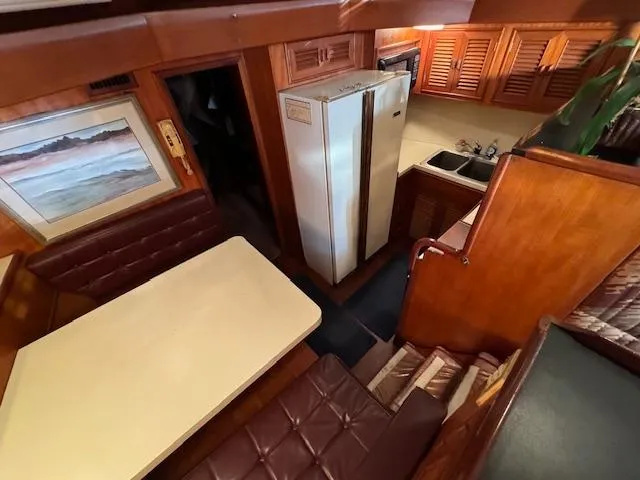 Slide: The Image of 1987 Seamaster 48 Motor Yacht interior with dining area, kitchen, and wood finishes. - 33