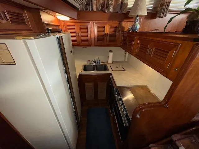 Slide: The Image of 1987 Seamaster 48 Motor Yacht kitchen with wooden cabinets, stove, and sink. - 35
