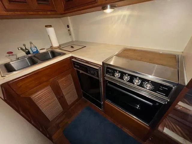 Slide: The Image of 1987 Seamaster 48 Motor Yacht kitchen with stove, sink, and wooden cabinets. - 36