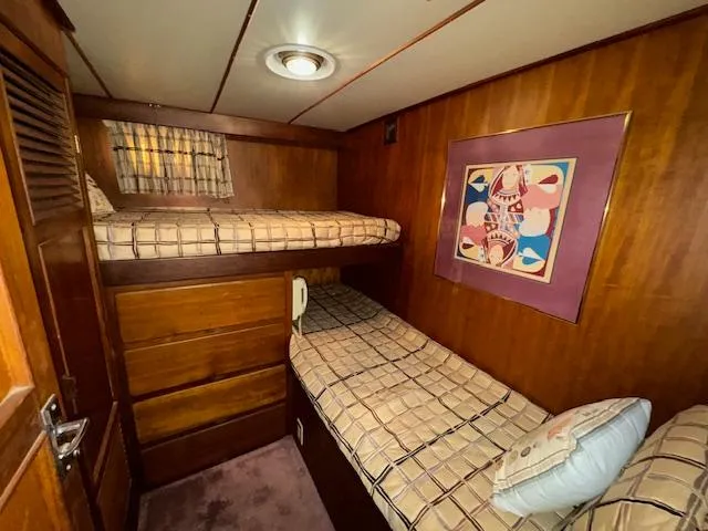 Slide: The Image of Cozy cabin with bunk beds in 1987 Seamaster 48 Motor Yacht, featuring wood paneling and artwork. - 45
