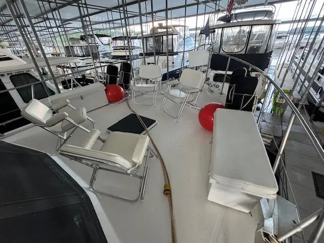 Slide: The Image of 1987 Seamaster 48 Motor Yacht deck with seating and red buoys in a marina. - 6