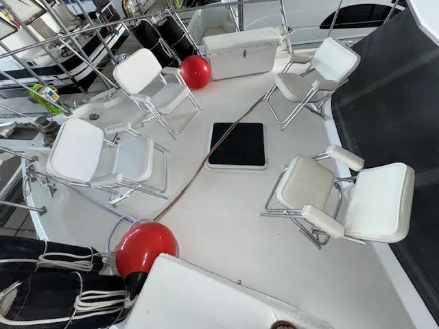 Slide: The Image of 1987 Seamaster 48 Motor Yacht deck with white chairs and red buoys. - 7