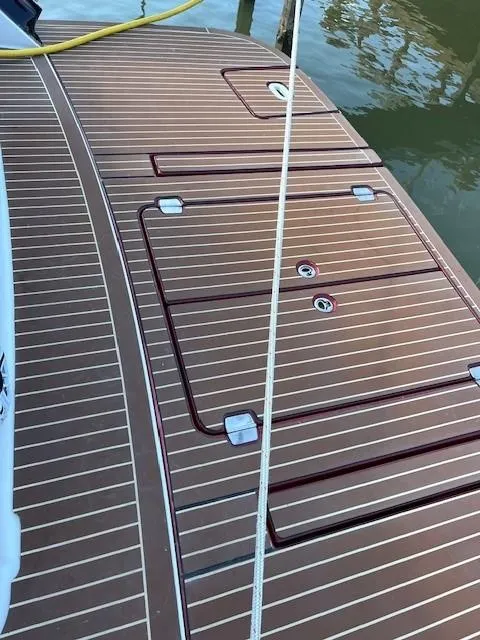 Slide: The Image of 2009 Four Winns V435 boat deck with wood-like finish and storage compartments. - 14