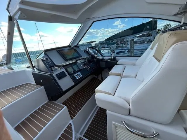 Slide: The Image of 2009 Four Winns V435 yacht cockpit with white seating and modern controls. - 32