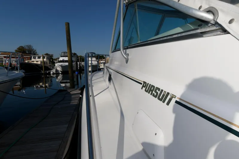 Slide: The Image of 2000 Pursuit 3400 Express boat docked at marina, side view. - 15