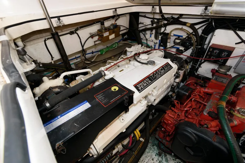 Slide: The Image of Engine room of a 2000 Pursuit 3400 Express boat, showcasing detailed mechanical components. - 19