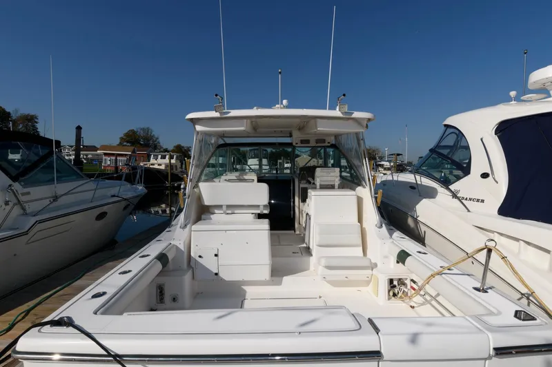 Slide: The Image of 2000 Pursuit 3400 Express boat docked, showcasing spacious deck and seating area. - 2