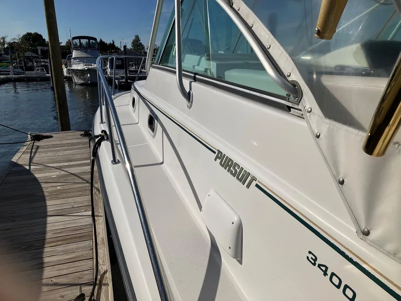 Slide: The Image of 2000 Pursuit 3400 Express boat docked at marina, side view. - 4